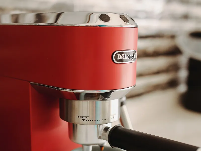 Red countertop espresso machine brewing coffee